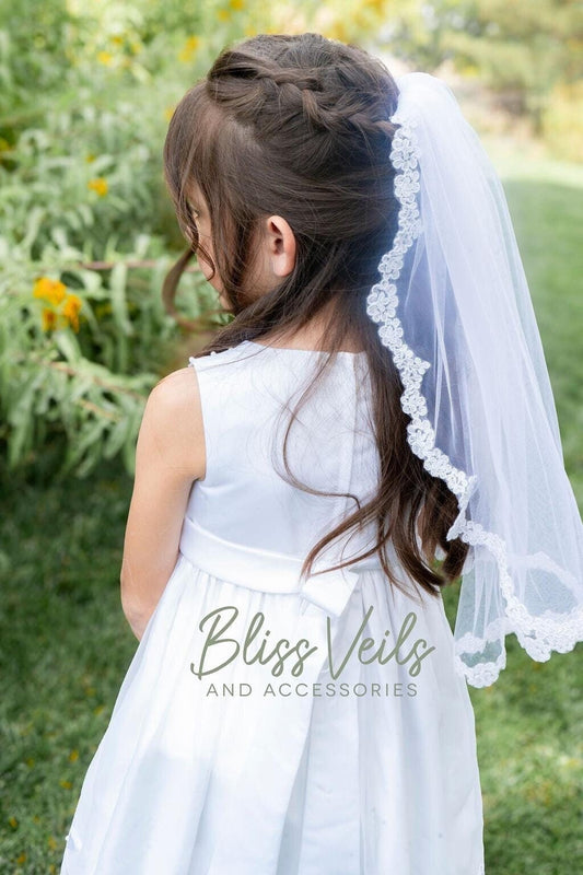 First Communion veil with thin scalloped lace edge in soft tulle, shown in 20 inch length, sewn to a small metal comb