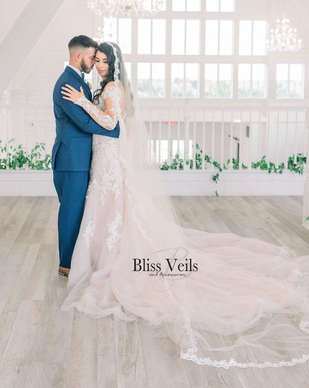 Cathedral length lace mantilla veil draped around gown